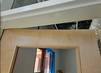  Door frame header with concealed overhead stop installed, viewed from below.