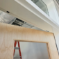 Interior door frame with concealed overhead stop mechanism discretely integrated into the frame header.
