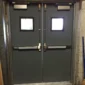 Fire-rated steel door with certification label in a commercial building corridor