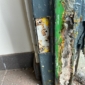 Frame section with peeling paint, rust, and concrete deterioration