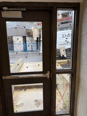 existing commercial steel entry door exterior before glass installation showing door vision panels
