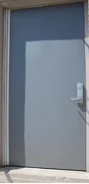 Commercial steel entry door with lever handle and full surface continuous hinge installation