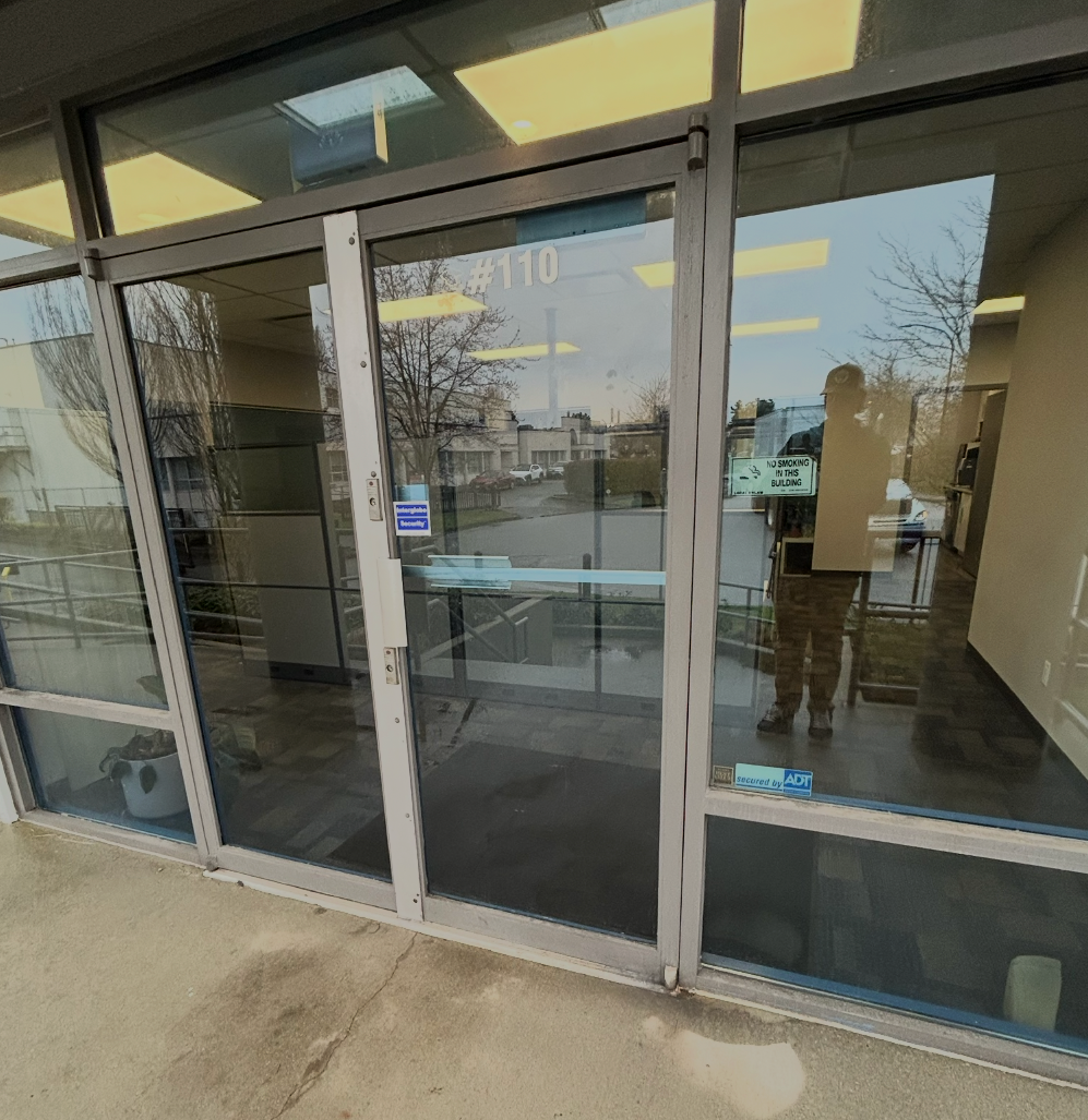 Commercial aluminum entry doors with pivot hinges at building entrance in Vancouver