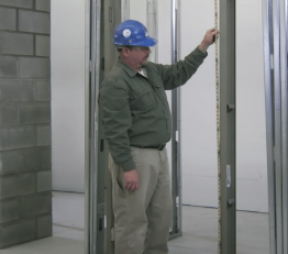 Technician inspecting a hollow metal door frame during commercial door installation in Vancouver.